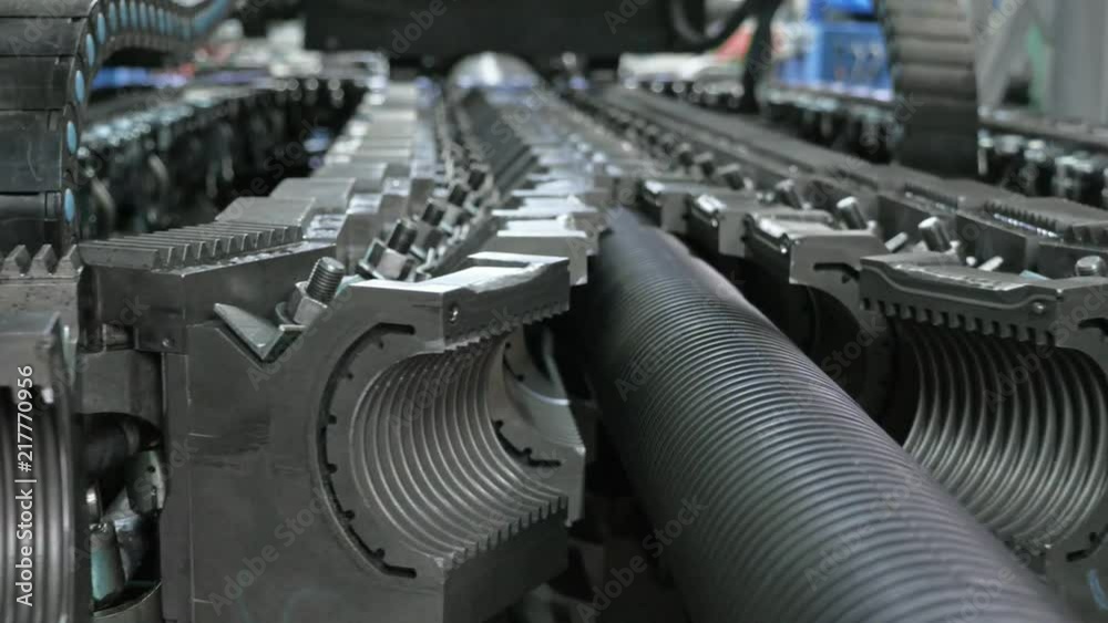 Manufacture of plastic water pipes. Manufacturing of tubes to the factory. The process of making plastic pipes on the machine tool with the use of water and air pressure. Special corrugated forms of