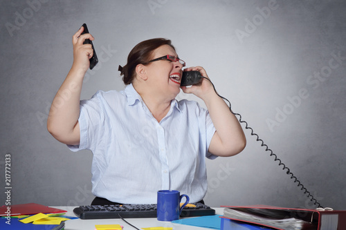 femme en colère et stressée au bureau téléphonant  photo