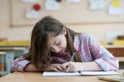 Little girl writing something in copybook