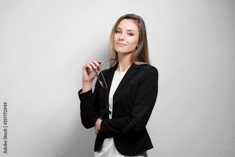 Portrait of a beautiful smiling woman in glasses in a business suit and jacket on a white background. Portrait of a beautiful smiling woman in glasses in a business suit and jacket on a white background.