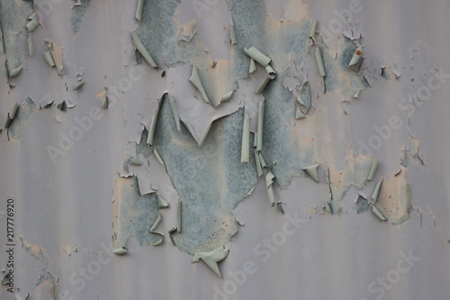 Close up shot a corrugated metal wall with peeling paint