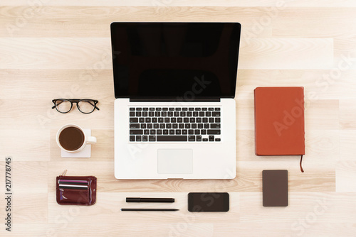 Top view laptop computer with phone, cup of black coffee, glasses, marker, pencil, diary, purse, hard drive on wooden background. Business template mock up. Minimal style. Flat lay, top view.