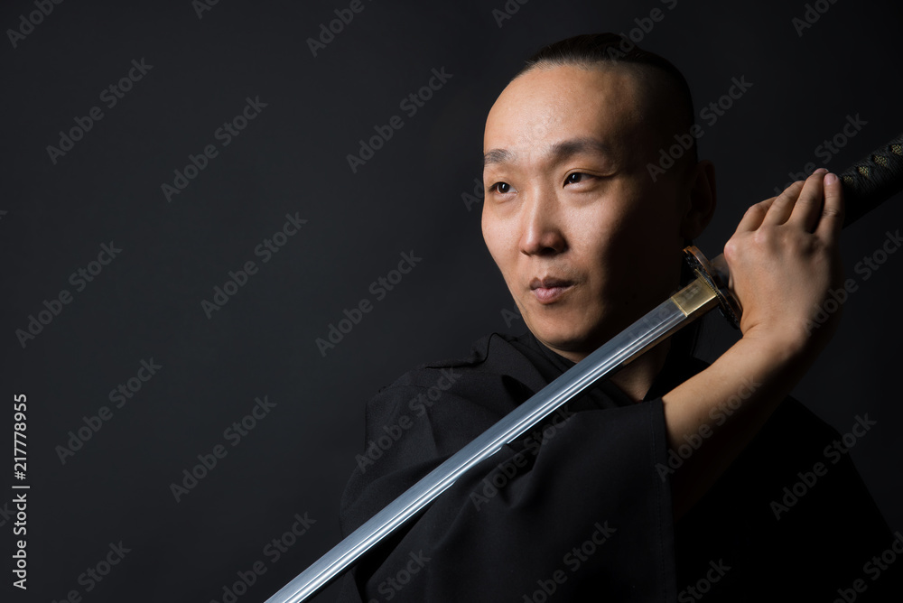 Portrait of a samurai man with a sword on a black background Portrait of a samurai man with a sword on a black background