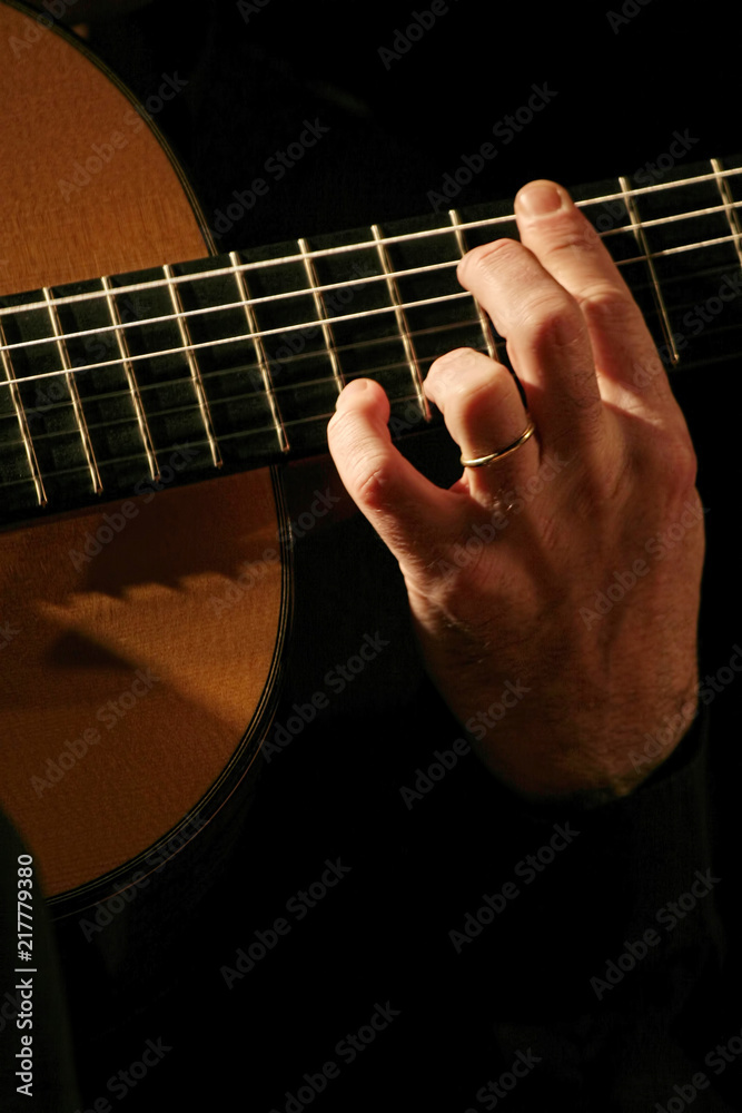 Fototapeta premium Man playing acoustic guitar close-up performance