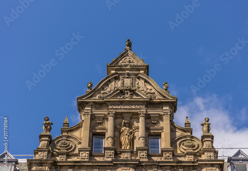 Edinburgh, Scotland, UK - June 13, 2012: Top niche of monumental brown stone facade of Department store on corner of Princess and South David streets under blue sky. © Klodien