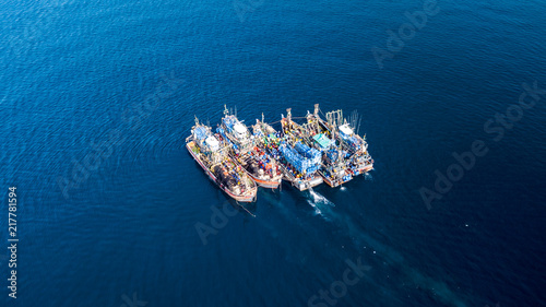 Aerial view of a large number of fishing trawlers operating together illegally in a marine reserve