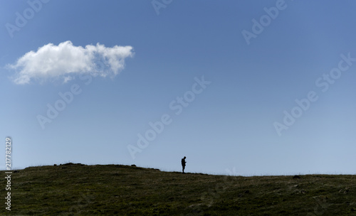 Man silhouette on hill with mobile phone in hand
