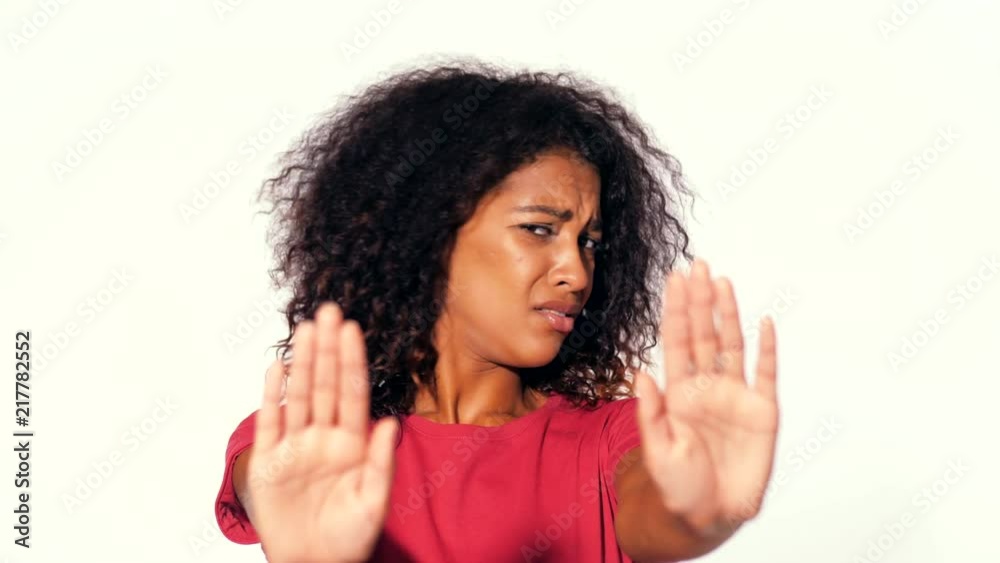 Angry annoyed woman raising hand up to say no stop. Sceptical and distrustful look, feeling mad at someone. Afro girl facial expressions, emotions and feelings. Body language Angry annoyed woman raising hand up to say no stop. Sceptical and distrustful look, feeling mad at someone. Afro girl facial expressions, emotions and feelings. Body language