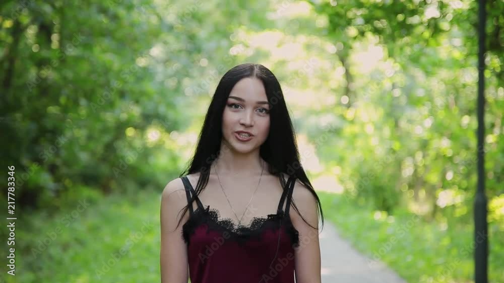 Beautiful girl is talking on the camera in a beautiful park. Beautiful girl is talking on the camera in a beautiful park.