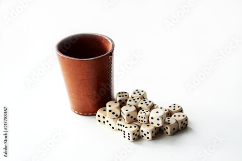 Cubes and a leather cup separated on white backdrop