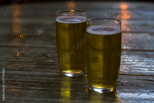 Glasses of beer on wooden table photo