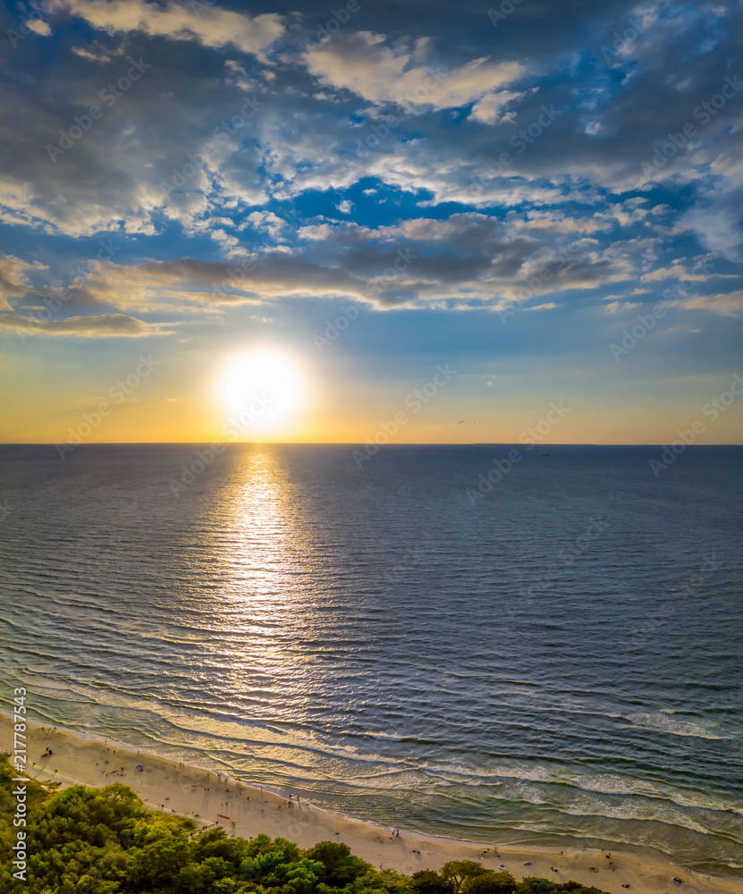 Ein wunderschöner Sonnenuntergang über dem Meer mit weißen Sand von ...
