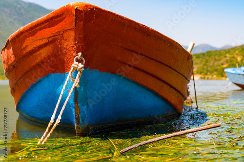 A closer look to a beautiful blue and red fishing boat, outside a greek village