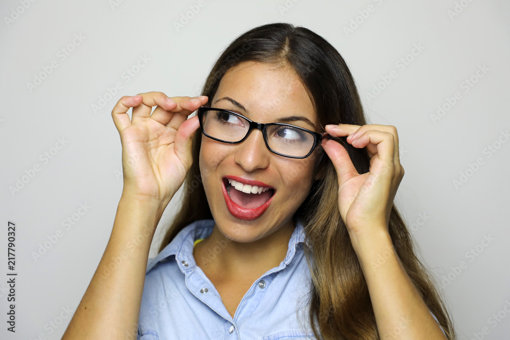 Excited woman put on her glasses and looking sideways screaming of joy. Closeup of happy mixed race female business woman isolated on gray background. Excited woman put on her glasses and looking sideways screaming of joy. Closeup of happy mixed race female business woman isolated on gray background.