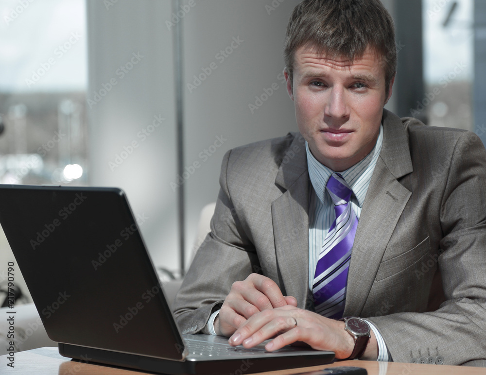 Attractive european guy talking on phone while using laptop. Attractive european guy talking on phone while using laptop.