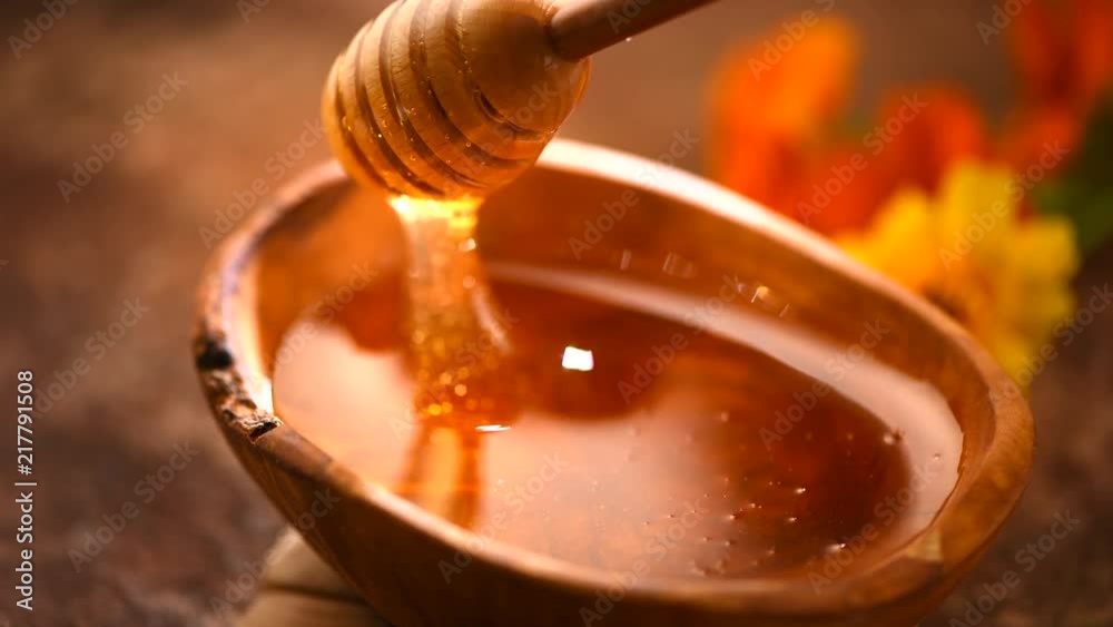 Honey dripping from honey dipper in wooden bowl. Healthy organic thick honey closeup. Slow motion. 3840X2160 4K UHD video footage Honey dripping from honey dipper in wooden bowl. Healthy organic thick honey closeup. Slow motion. 3840X2160 4K UHD video footage