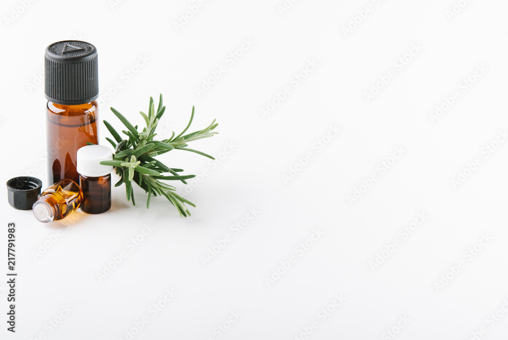 essential oils with botles and herbs on white background essential oils with botles and herbs on white background