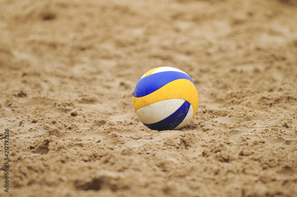 Volleyball yellow and blue in the sand