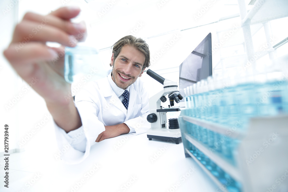 Portrait of a chemist holding a tube with liquid. Portrait of a chemist holding a tube with liquid.