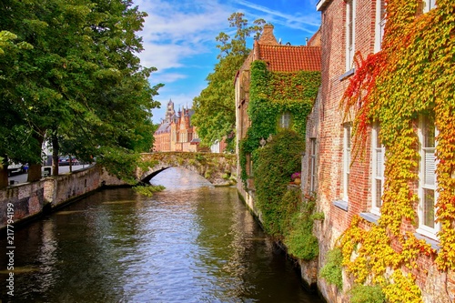 Bridge and leafy buildings lining the picturesque canals of Bruges, Belgium