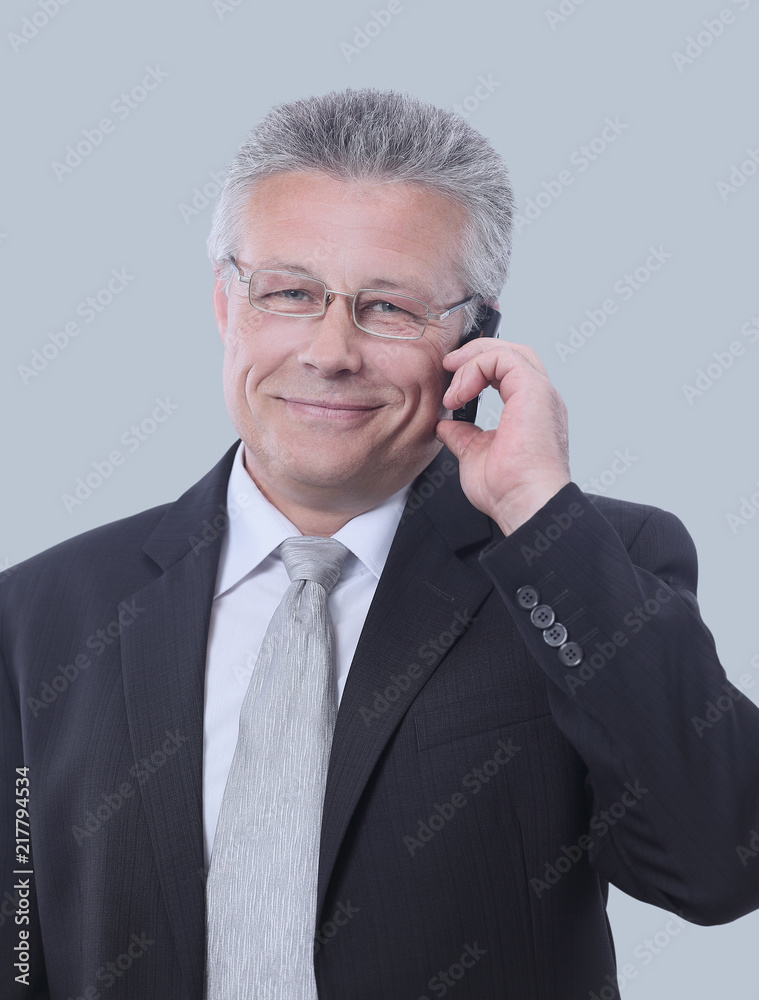 Portrait of smiling senior businessman standing against gray Portrait of smiling senior businessman standing against gray