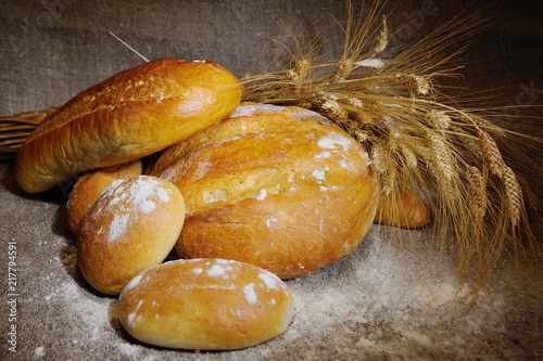 bread, loaf, white bread, wheat ears on a background of burlap. Agriculture. harvest