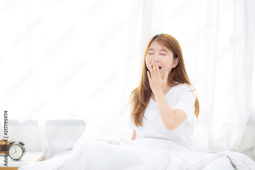 Beautiful of portrait young asian woman yawn sitting with sleep on bed at bedroom, girl wake up after resting and leisure with wellness, lifestyle concept. Beautiful of portrait young asian woman yawn sitting with sleep on bed at bedroom, girl wake up after resting and leisure with wellness, lifestyle concept.