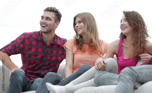 group of cheerful friends sitting on the couch