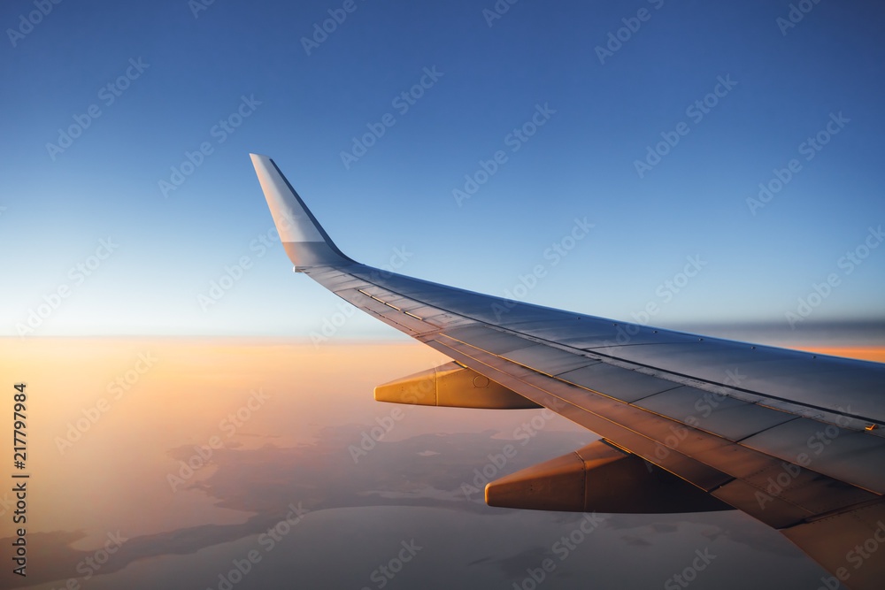 Fototapeta premium skrzydło samolotu na tle zachodu słońca niebo