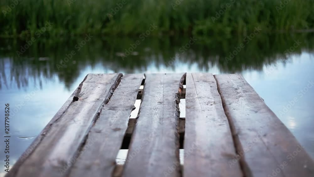 wooden original quay against the background of the flowing water of the river. wooden original quay against the background of the flowing water of the river.