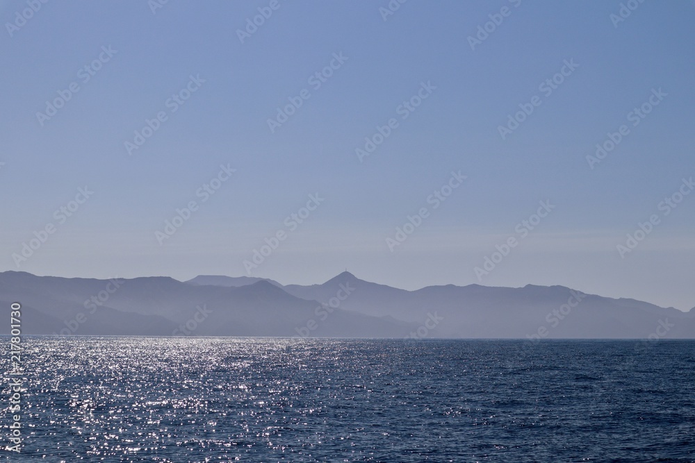 open ocean with island mountains in background 