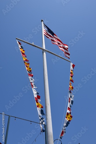 American flag on ship's mast with pennants 