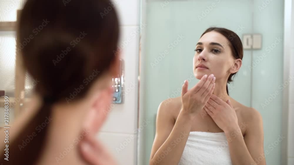 Skin Care. Woman Touching Face And Looking At Mirror At Bathroom Skin Care. Woman Touching Face And Looking At Mirror At Bathroom