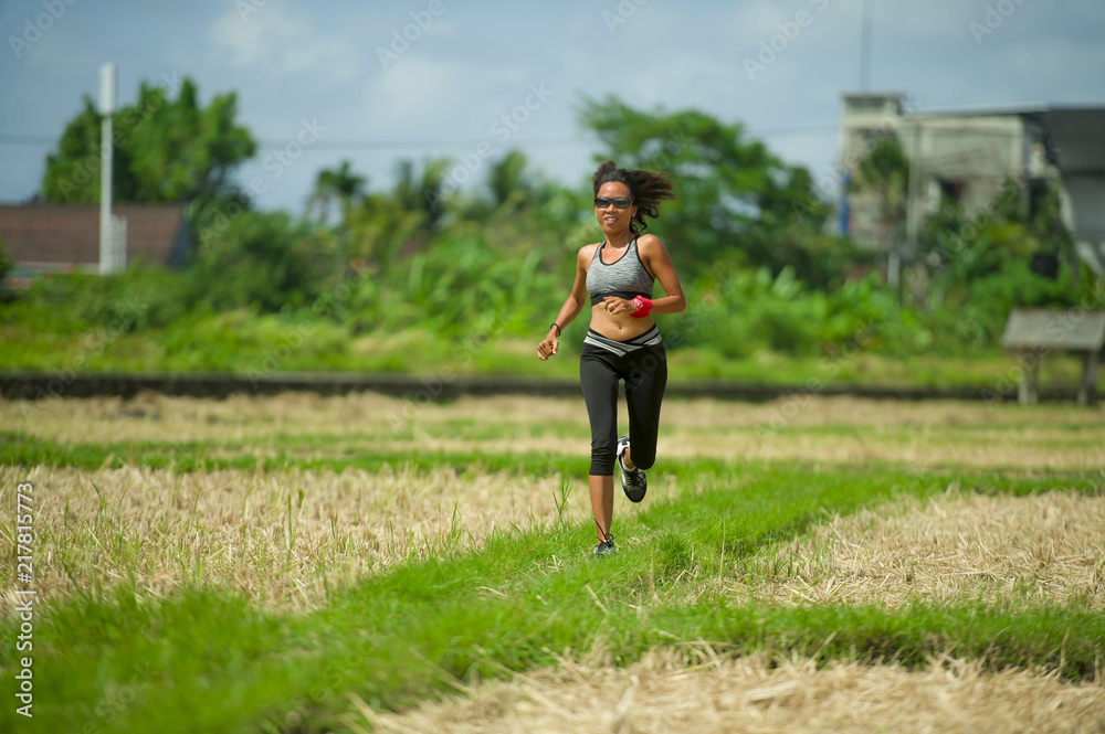healthy lifestyle portrait of young happy and fit Asian Chinese runner woman in running workout outdoors at green field background in body fitness concept healthy lifestyle portrait of young happy and fit Asian Chinese runner woman in running workout outdoors at green field background in body fitness concept