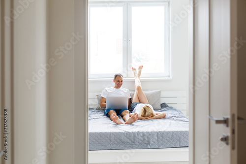 Close up Young Sweet Couple on Bed Watching Something on White Tablet Gadget.