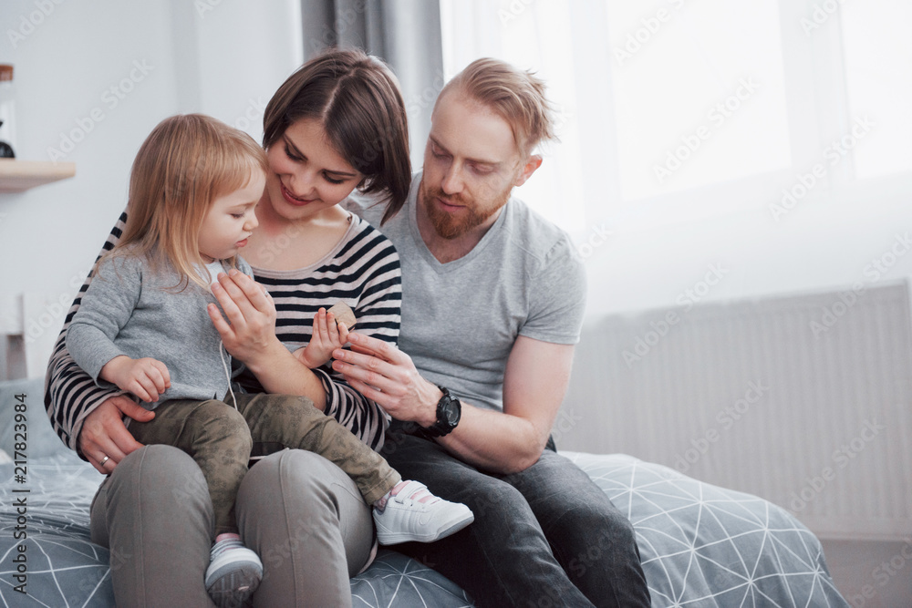 happy family mother, father and child daughter laughs in bed