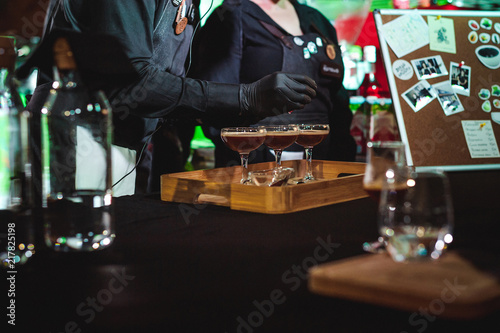 championship among coffee houses, members of teams show barista's skill, prepare drinks, teamwork. pours drink into glasses