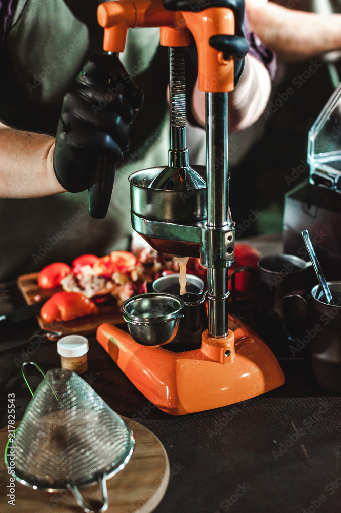 man's hand squeezes juice from citrus on a professional mechanical
