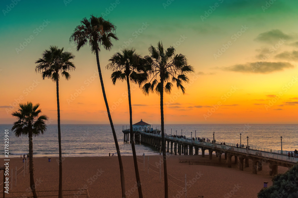 Fototapeta premium Palm trees and Pier on Manhattan Beach at sunset in California, Los Angeles, USA. Vintage processed. 