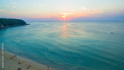 aerial view the sun going down to holison at Karon beach Phuket two jet boats sail in Karon sea during sunset .