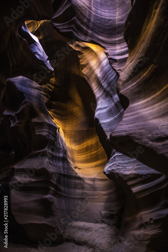 sunlight reflects orange and red across the sandstone inside Antelope Canyon