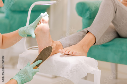 Female chiropodist. Professional skillful female chiropodist working hard in her beauty salon providing good service photo