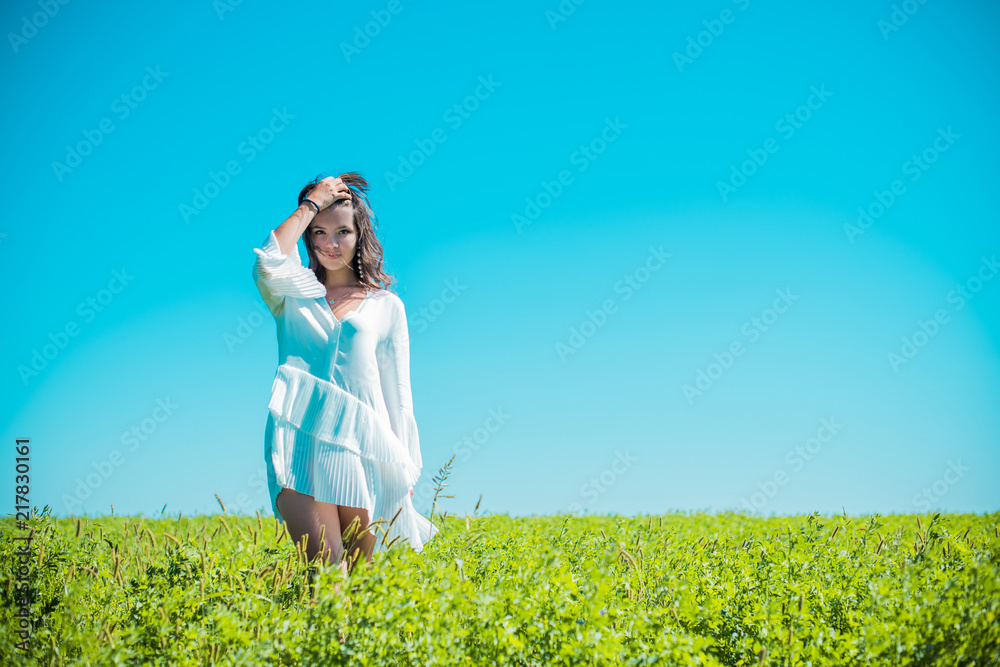 Freedom concept, romantic photo of fashion girl in green field, white fashionable dress, Beauty Romantic Girl in white dress Outdoors 
