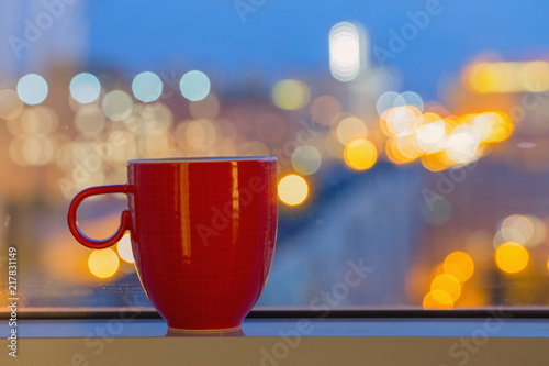 red cup on windowsill in city