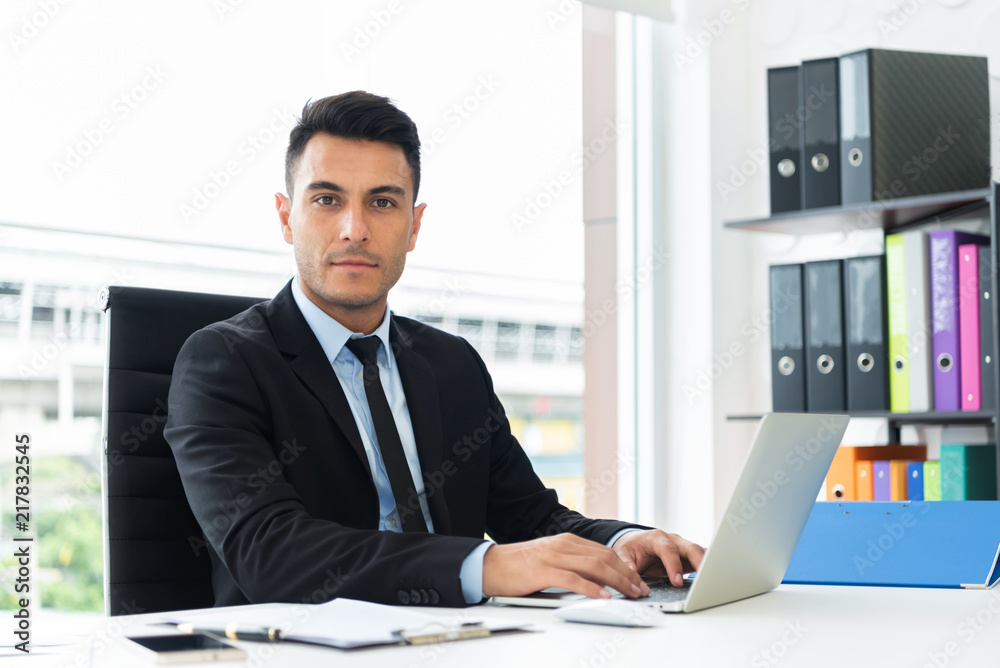 Portrait of a confident businessman working on laptop. Portrait of a confident businessman working on laptop.