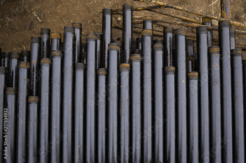 Oil Drill pipe. Rusty drill pipes were drilled in the well section. Downhole drilling rig. Laying the pipe on the deck. View of the shell of drill pipes laid in courtyard of the oil and gas warehouse.