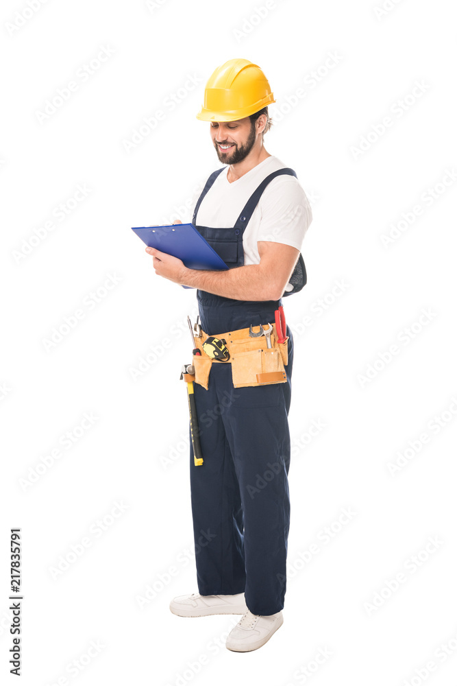 full length view of smiling workman in tool belt writing on clipboard isolated on white full length view of smiling workman in tool belt writing on clipboard isolated on white