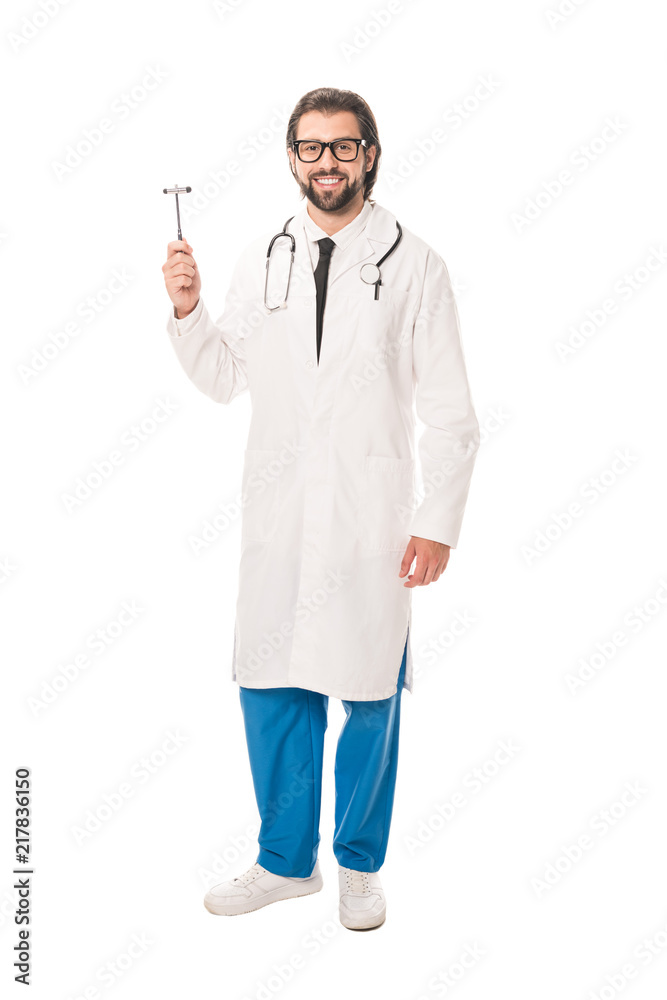 full length view of doctor holding reflex hammer and smiling at camera isolated on white