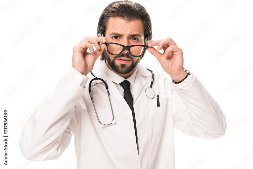 bearded doctor in white coat adjusting eyeglasses and looking at camera isolated on white bearded doctor in white coat adjusting eyeglasses and looking at camera isolated on white