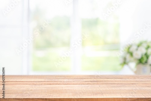 Blur background of white window glass and green view from garden with epty of wood table.